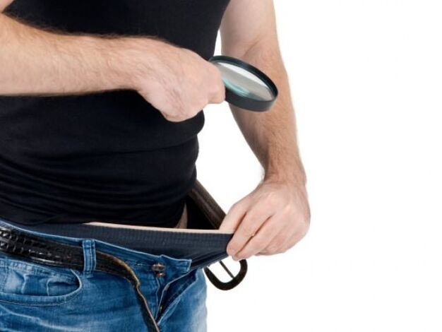 un uomo si guarda nei pantaloni e vuole ingrandire il suo pene